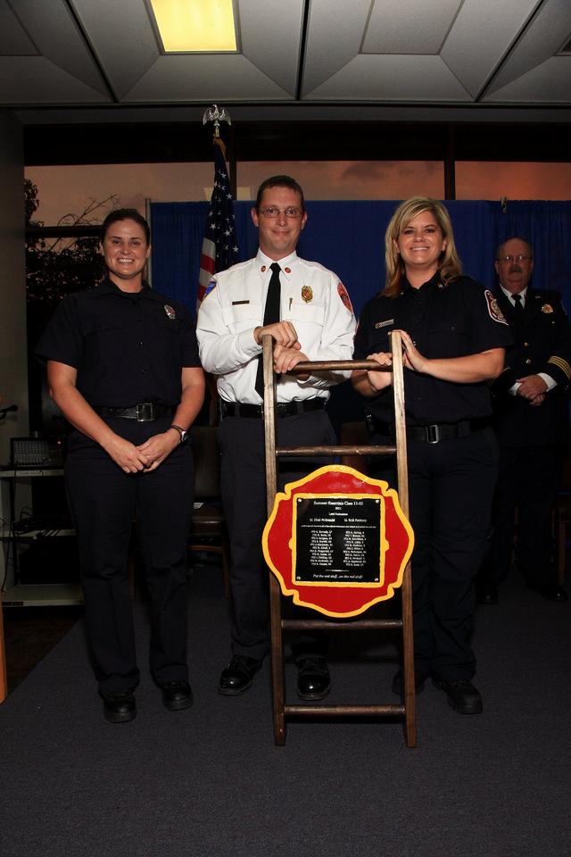 Rachel Burrell presents the Instructor Chad McDonald of Firefighter 2 Class 11-3 with a class appreciation display. Photo by Ed Tenney

